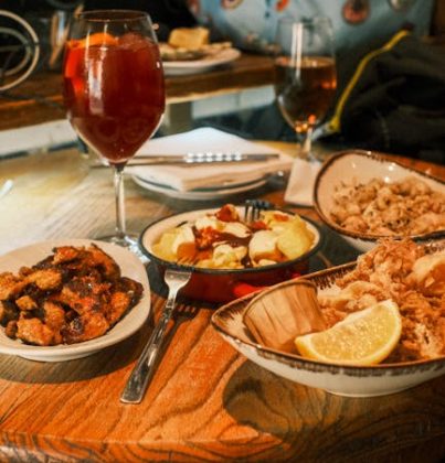 A table set with a variety of Spanish tapas and a glass of sangria in a cozy Barcelona restaurant.